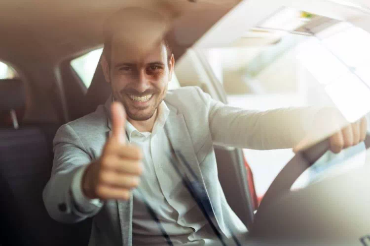 Conducteur au volant avec son pouce vers le haut