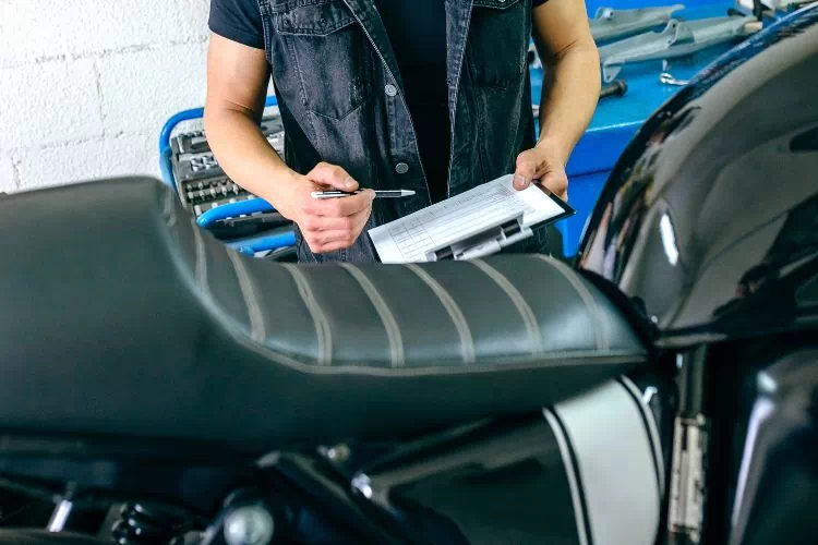 Homme effectuant le contrôle technique d'une moto