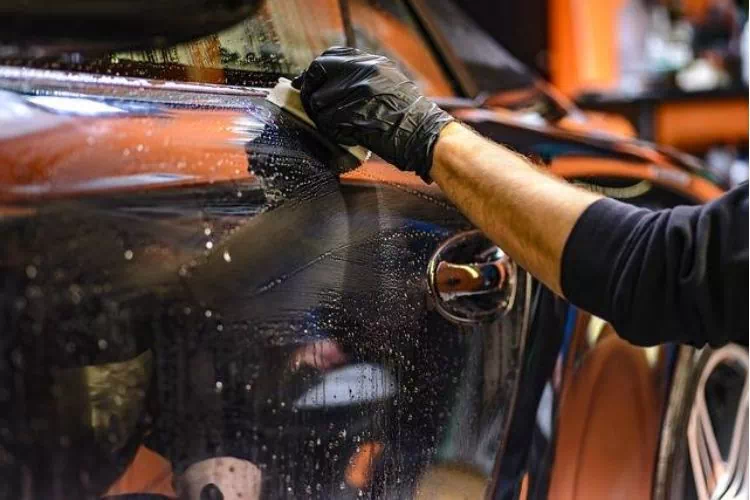 Homme en train de nettoyer l'extérieur d'une voiture