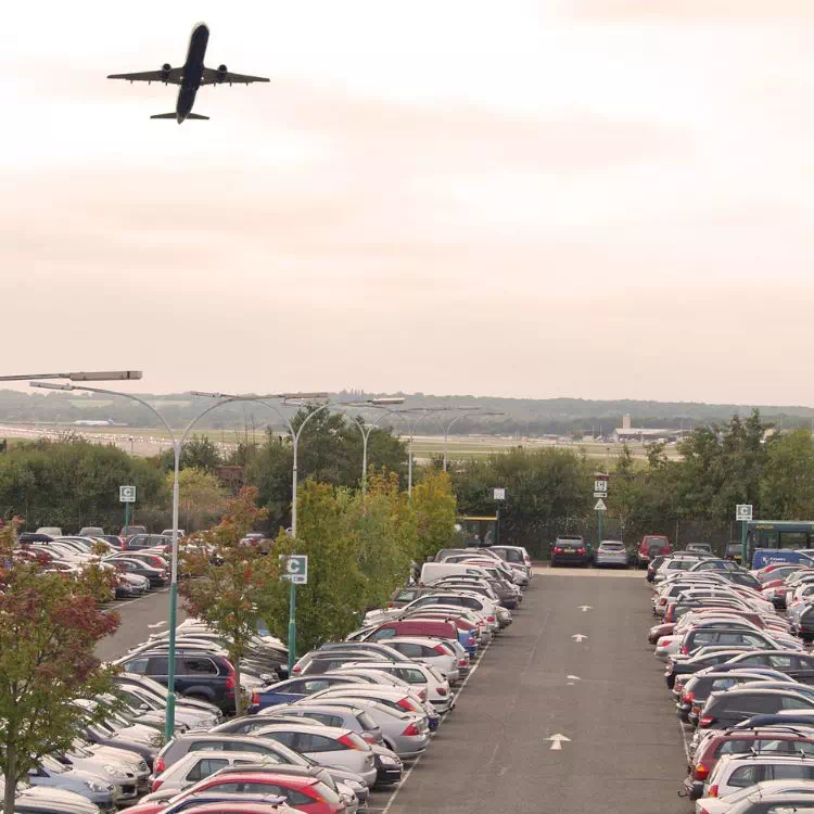 Avion décollant et passant au-dessus du parking de l'aéroport