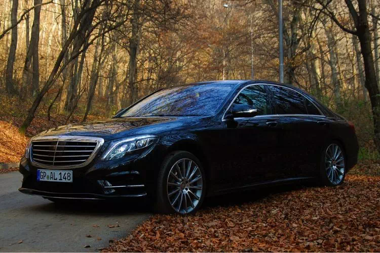 Mercedes classe S noire sur une route de campagne