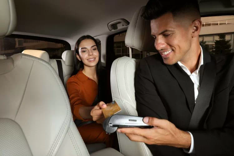 Chauffeur VTC en train de faire payer une cliente par carte bancaire