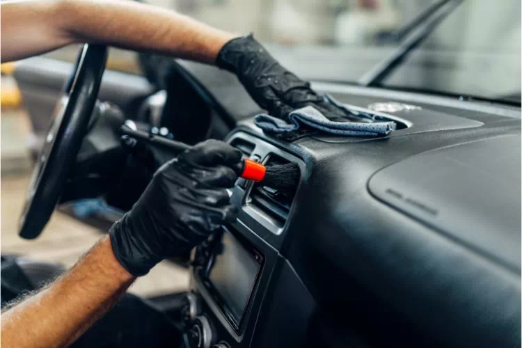 Homme peignant au pinceau un élément du tableau de bord