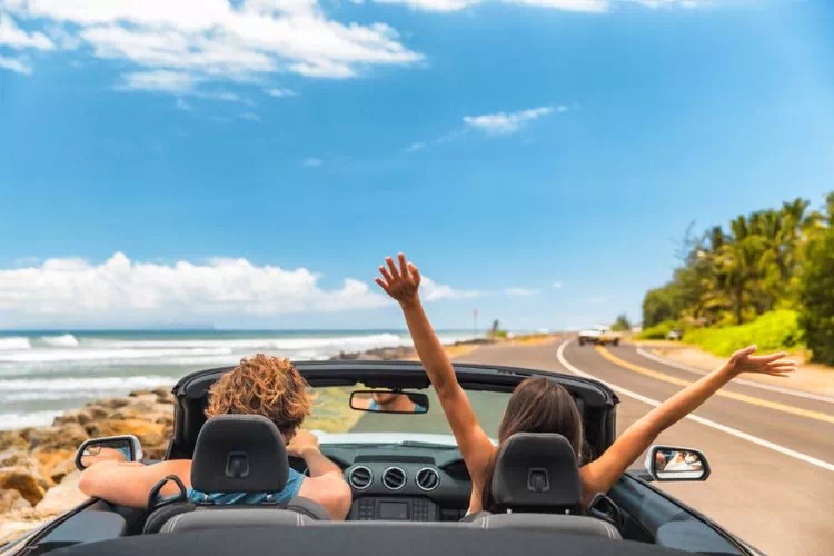Jeune couple en road trip dans un cabriolet
