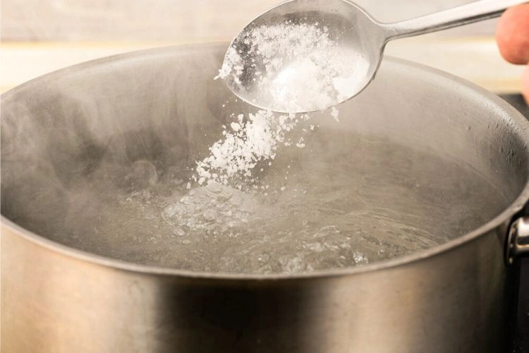 Culière de bicarbonate dans de l'eau chaude pour nettoyage de jantes