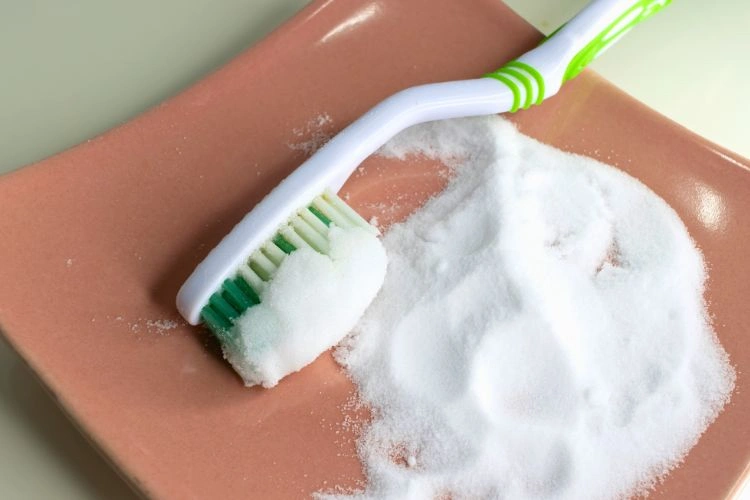 Brosse à dents et bicarbonate pour représenter les méthodes inefficaces sur le long terme pour nettoyer les optiques de phares