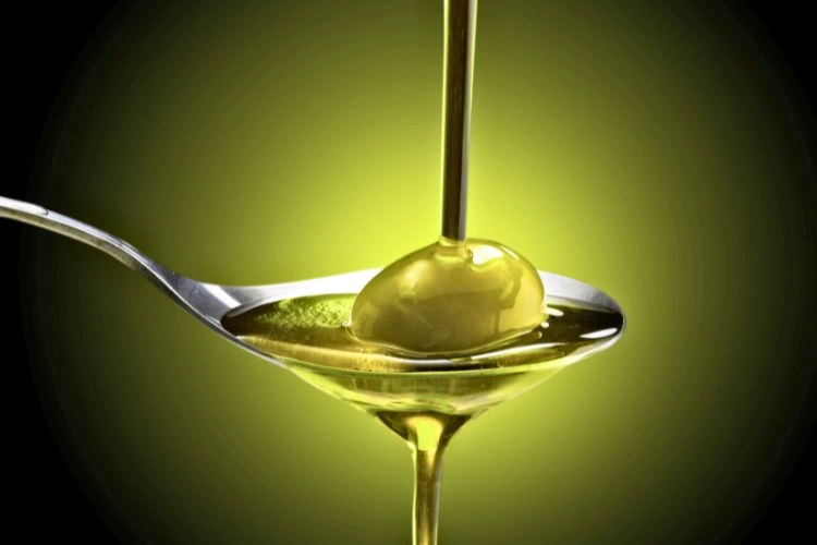 Huile d'olive coulant sur une culière pouvant permettre de nettoyer les phares de véhicule