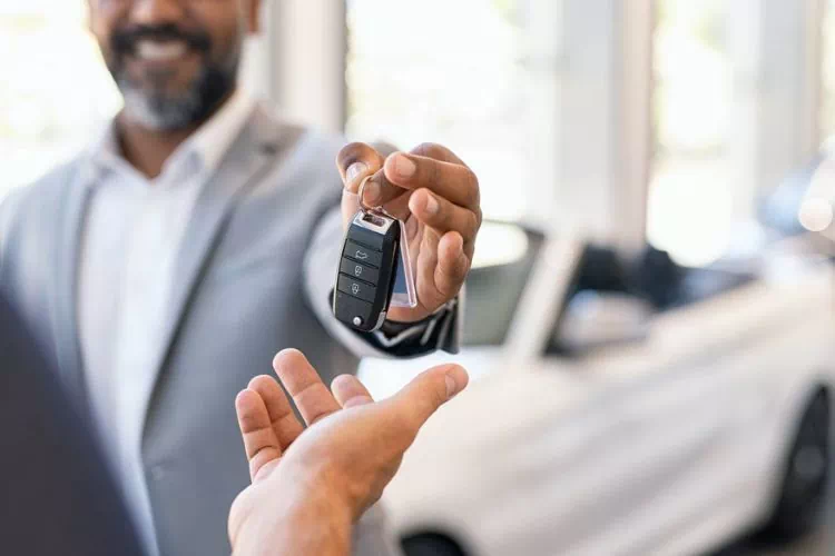 Homme donnant les clés suite à une vente de voiture