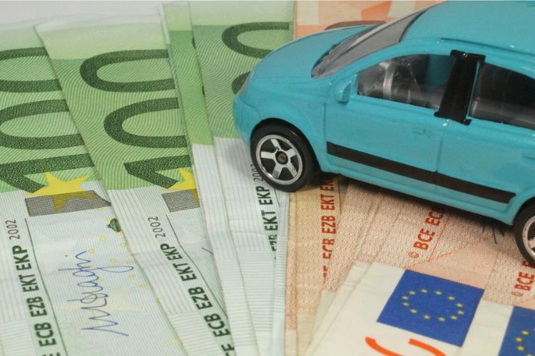 Véhicule miniature posé sur des billets