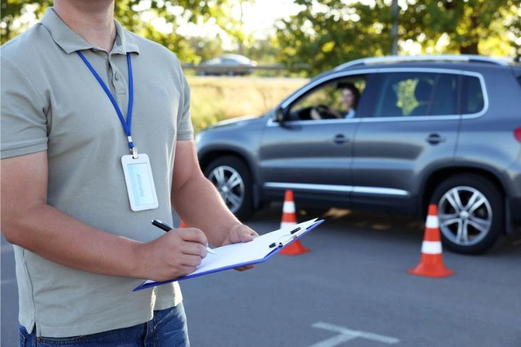 Moniteur d'auto-école debout en plein examen