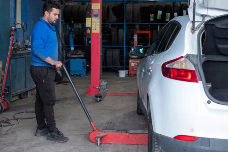 Mécanicien soulevant une voiture avec un cric