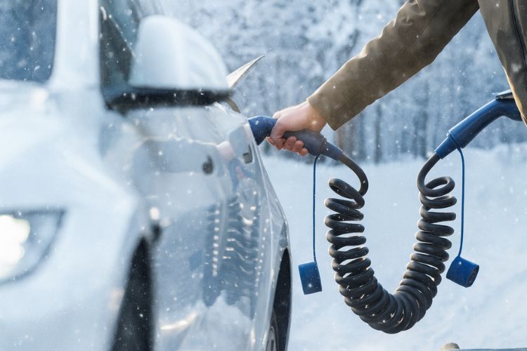 Homme branchant un câble Voldt pour charger sa voiture électrique