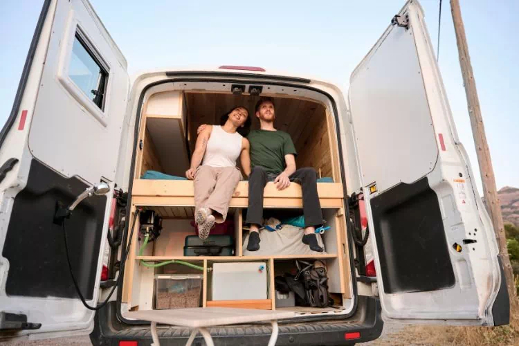 Couple dans leur van aménagé pendant un road trip