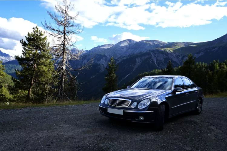 Berline Mercedes sur un chemin à la montagne