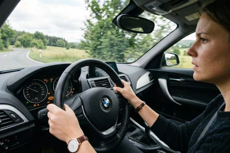 Personne au volant d'une BMW série 1 avec le voyant FAP allumé