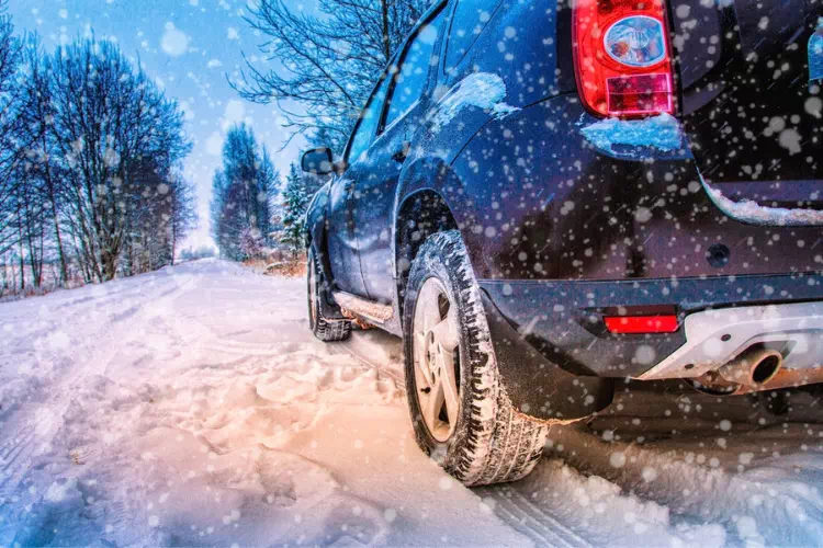 Voiture sous la neige avec des pneus hiver